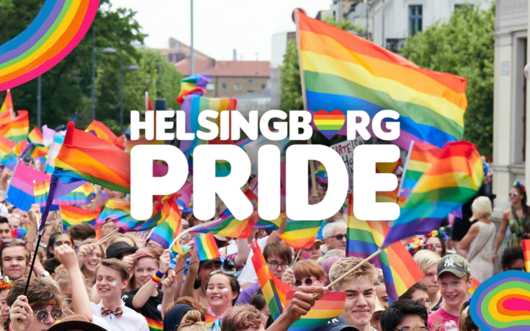 Pride i Helsingborg, på bilden syns människor som håller i flaggor regnbågens färger.