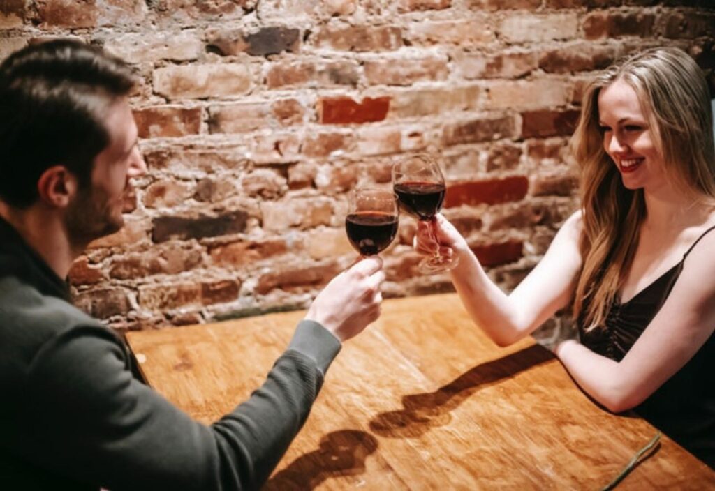 två personer skålar med rödvin