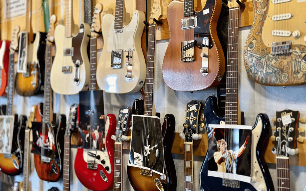 Flertalet elgitarrer hänger på en vägg.