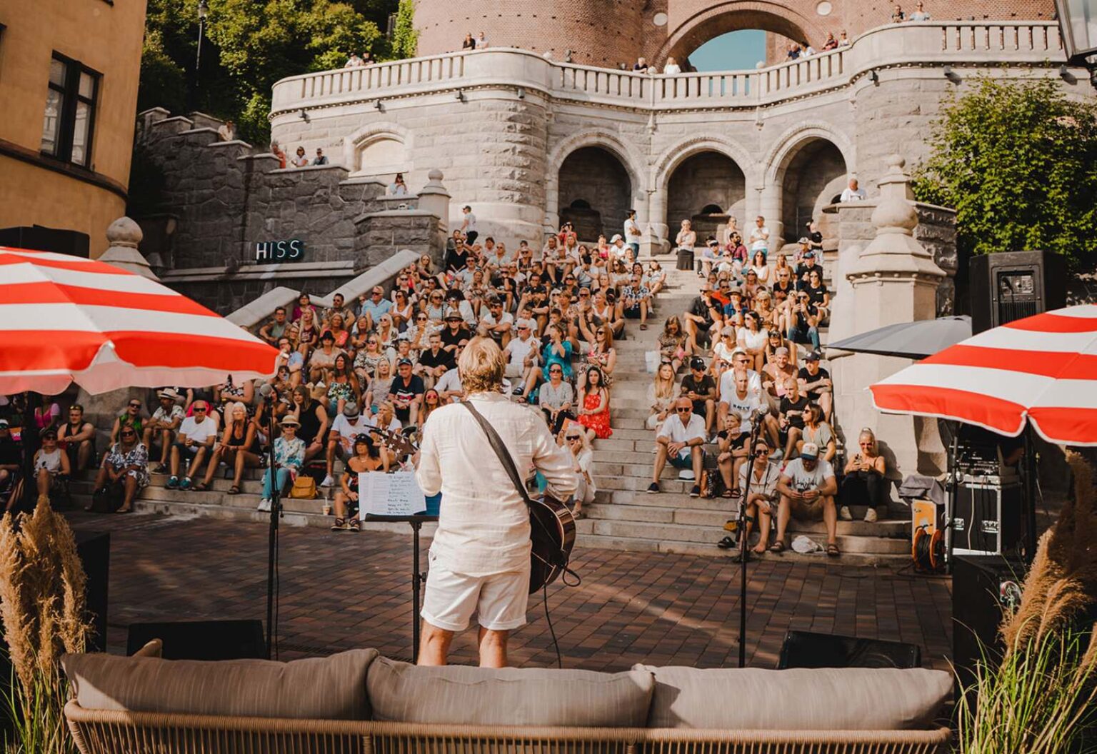 Terrasstrapporna, där det sitter folk som lyssnar på en person som spelar gitarr