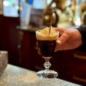 En hand håller fram en irish coffee.
