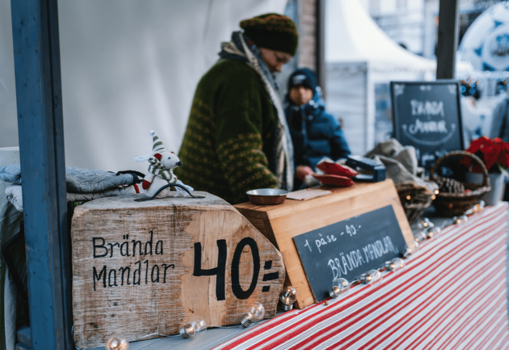 En kvinna säljer brända mandlar i ett marknadsstånd.