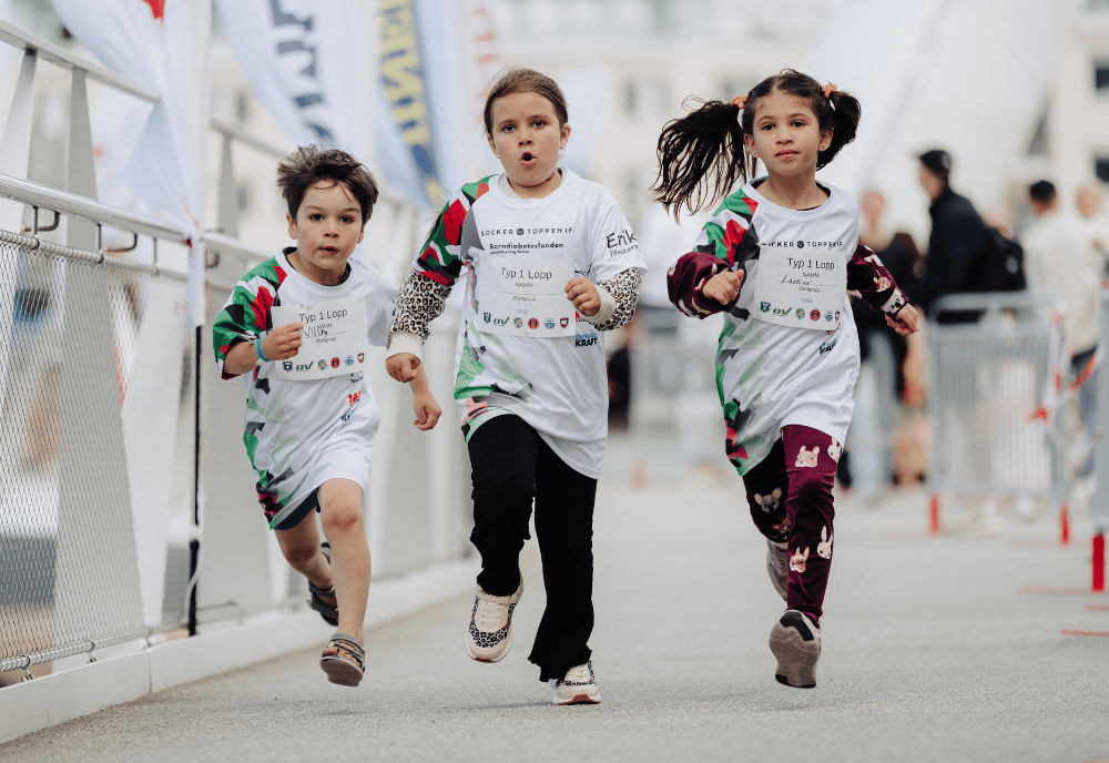 Tre barn springer och har på sig