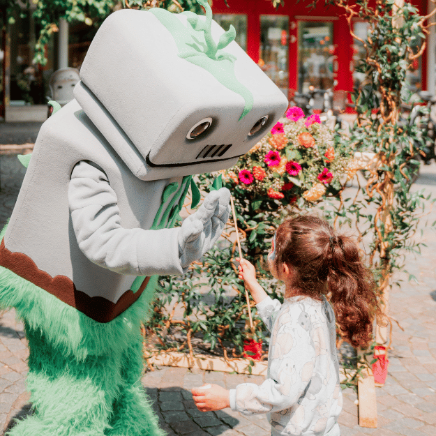 En maskot ger high five till en flicka.