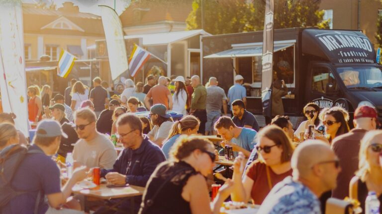 Ett torg med människor som sitter på bänkar och äter streetfood.