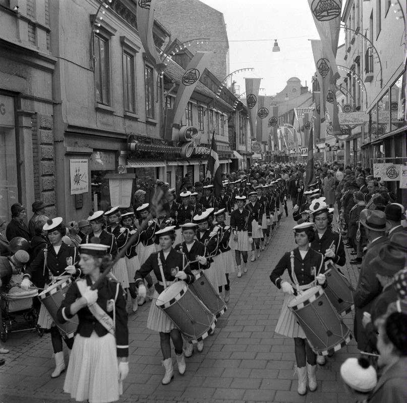 En svartvit bild på invigningen av Kullagatan 1961. Ett band marscherar längst med gatan.