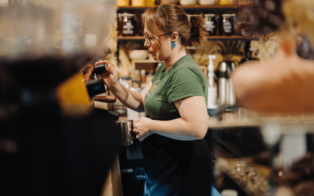 En kvinna gör kaffe på ett café.
